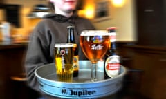 A server carries a tray with drinks including Jupiler and Leffe