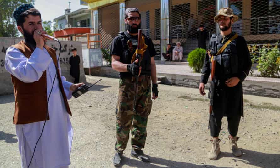Taliban forces stand guard outside the passport office in Kabul