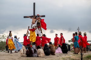Colourful costumes as man is nailed to an erect cross