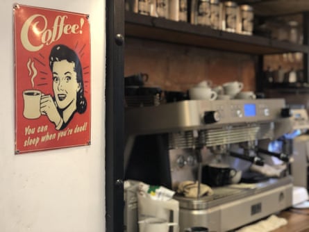 a sign reading ‘coffee - you can sleep when you’re dead’ close to a coffee machine