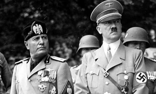 Benito Mussolini and Adolf Hitler attend a military parade together with high officials of the Wehrmacht in 1937