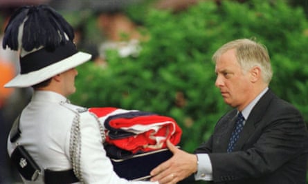 Chris Patten recebe uma bandeira britânica dobrada após sua queda no Palácio do Governo em Hong Kong, em junho de 1997.