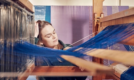 Hannah Robson seen across the blue threads of her loom