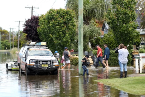 People carry sandbags through flood waters in Forbes yesterday