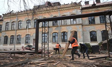 Workers clean debris outside the damaged Lviv National University of Nature Management, after a drone attack on Monday. 