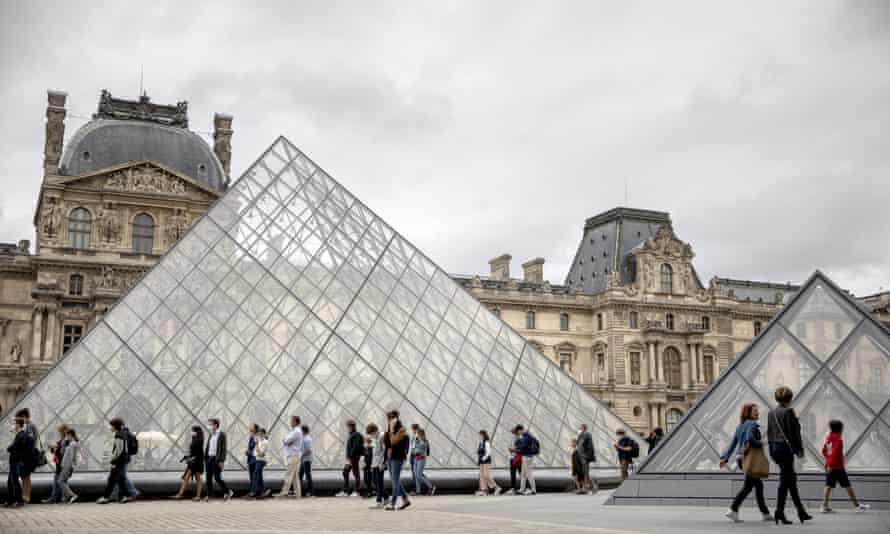 Visitors hold successful enactment successful beforehand of the Louvre’s pyramid successful Paris, Friday, Aug. 6, 2021