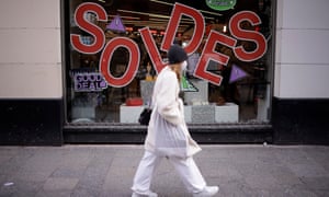 A woman walks past sale signs on shop windows in Paris, France, 20 January 2021.