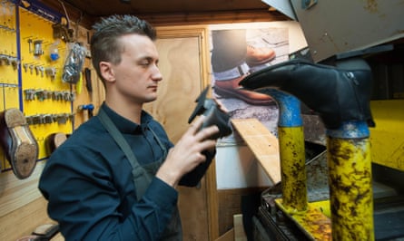 Cobbler repairing leather shoes inside a traditional workshop.