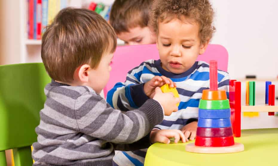 Two boy toddlers stacking colourful shapes together