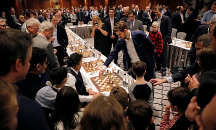 Magnus Carlsen with one of his 21 opponents at the Four Seasons Hotel in London.