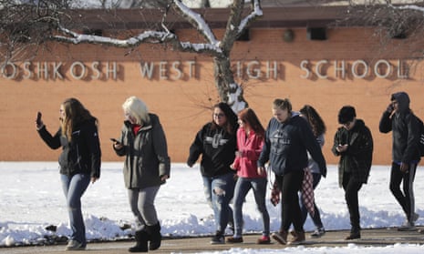 Students are evacuated from Oshkosh West high school on Tuesday after a resource officer shot a 16-year-old student after the boy stabbed him in the officer’s office.