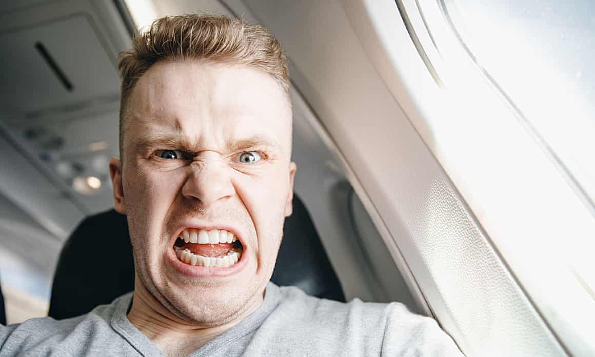 Stock image of an angry-looking man on a plane