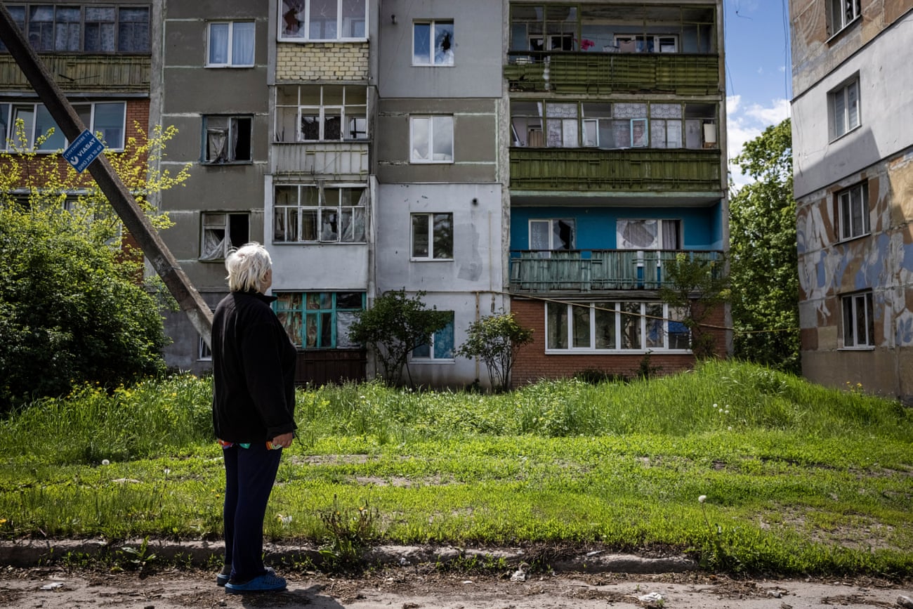 Nadiya Rykova looks up at her destroyed appartment building in Kutuzivka.