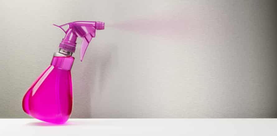 A bright pink spray bottle spritzing out some cleaning fluid