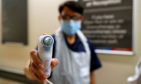 A nurse in PPE holds a thermometer at Wexham park hospital in Berkshire.