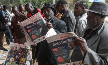 Men read about the 2022 election in a Kenyan daily newspaper.
