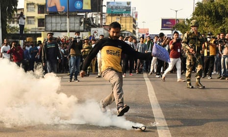 A demonstrator kicks a teargas shell fired by police to disperse protesters. 