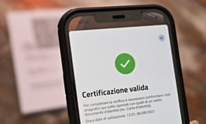A bar owner shows a valid Green Pass on the VerifyC19 mobile phone application in central Rome.