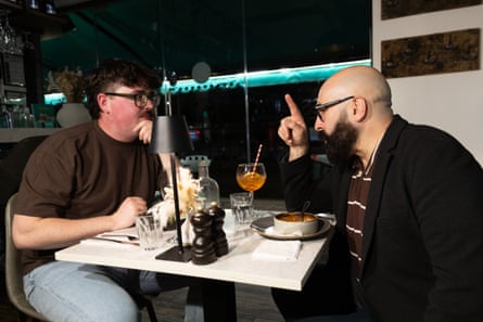 Two men facing each other across a restaurant table