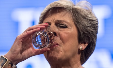 Theresa May pauses to drink a glass of water during her speech