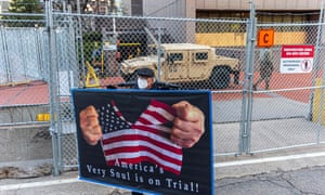 A protester holds a sign outside the Hennepin County Government Center court house before the opening statements in former Minneapolis Police officer Derek Chauvin murder trial on March 29