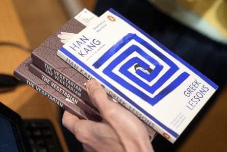 A book store worker handles books by the South Korean writer Han Kang in London