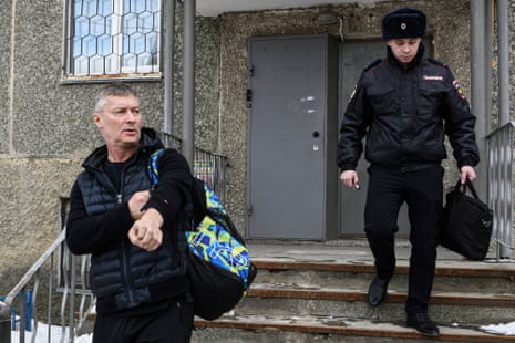 Yevgeny Roizman, former mayor of Russia's fourth-largest city, walks escorted by a police officer in Yekaterinburg, Russia.
