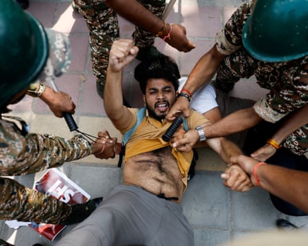 A protester detained by security personnel.