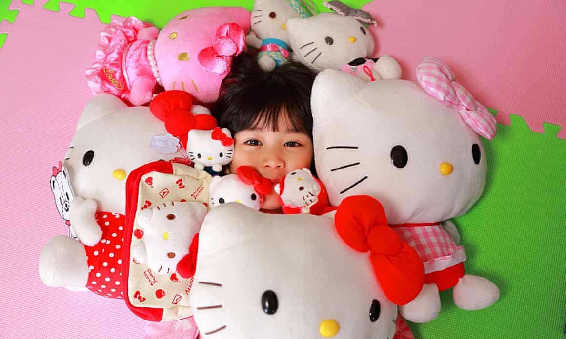 A girl surrounded by Hello Kitty cuddly toys
