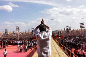 Vijay is photographed from behind addressing a huge crowd of suppporters. Drones fly above the crowd