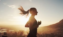 A young woman running high above a cityscape at sunrise