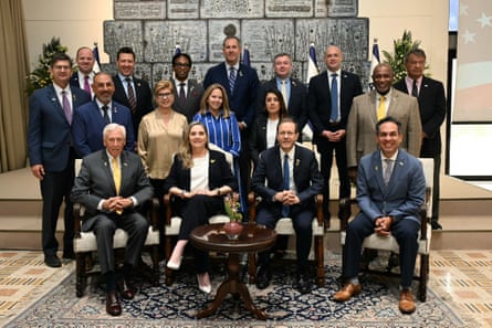 a group of people in formal wear sit and stand together