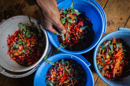 Four buckets filled with a mixture of red, orange and green vegetables.