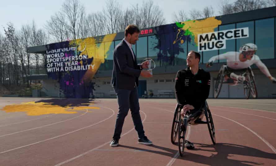 Marcel Hug receives his Laureus award from his compatriot, cyclist Fabian Cancellara.