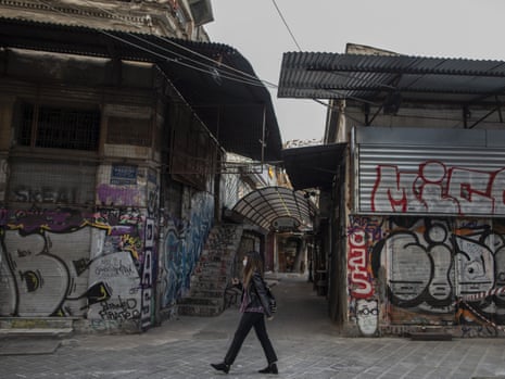 A woman wearing a face mask walks outside shuttered shops in Monastiraki district, central Athens. Greek authorities have registered a new record high of 41 Covid-19 deaths, three days into a new lockdown, but a drop in new infections.
