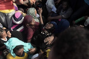 A woman faints while refugees and migrants wait to be rescued by members of Proactiva Open Arms NGO
