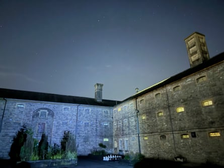Shepton Mallet Prison’s stone buildings with barred windows stand beneath a starry night sky