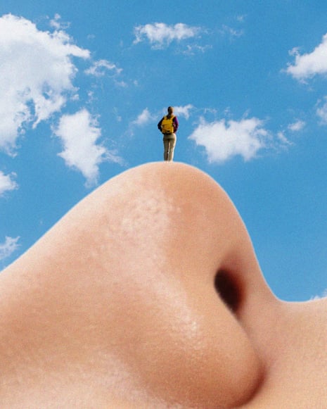 A person stands on a giant nose under a sky with clouds