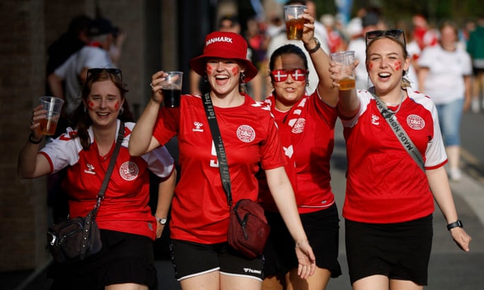 Denmark fans raise a glass outside the stadium.