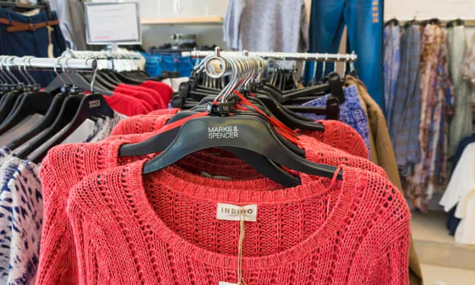 red jumpers and other clothes on the rails at M&S