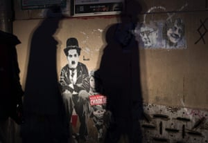 People walk past a mural depicting Charlie Chaplin