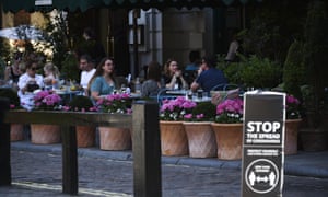 People eating outside at a restaurant, in London,in late July.