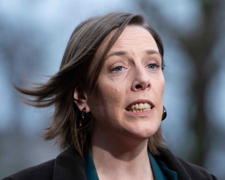 Former safeguarding Minister Jess Phillips speaks while looking upward, with hoop earrings and hair blowing to one side.