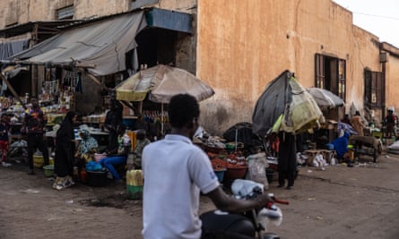 A man riding a motorcycle at a market in Niamey.