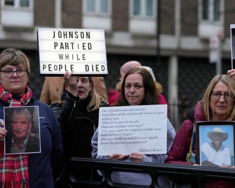 Protesters stand outside Dorland House holding pictures of Covid victims and placards as Boris Johnson testified in December 2023