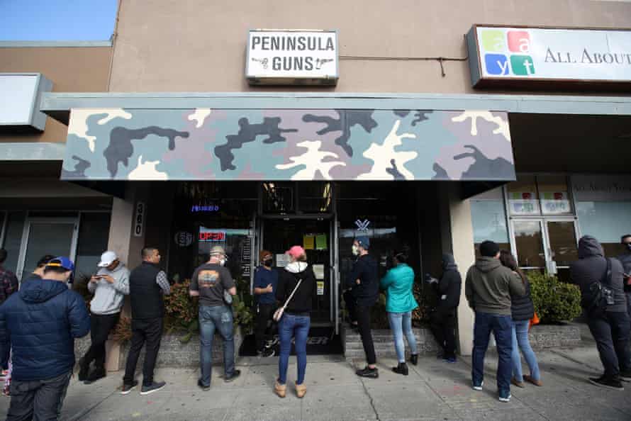 People wait in line to purchase guns and ammunition in San Bruno, California.