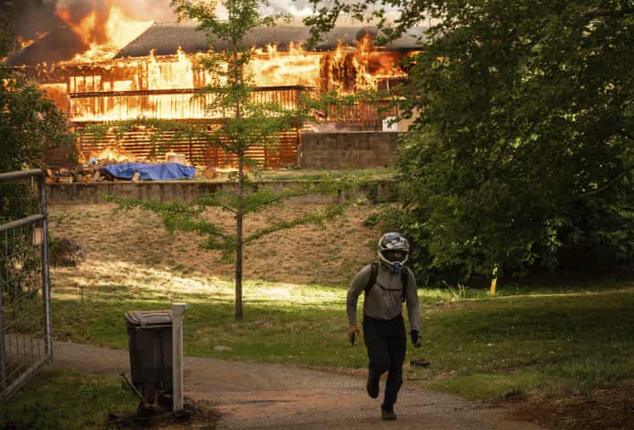 A man quickly leaves after checking a house burning in the River fire in Nevada county, California.