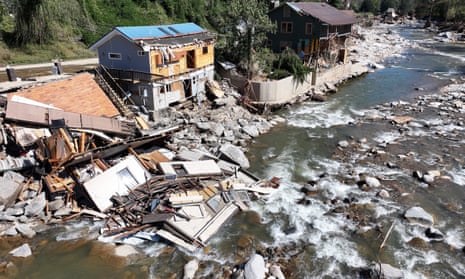 row of damaged buildings next to body of water