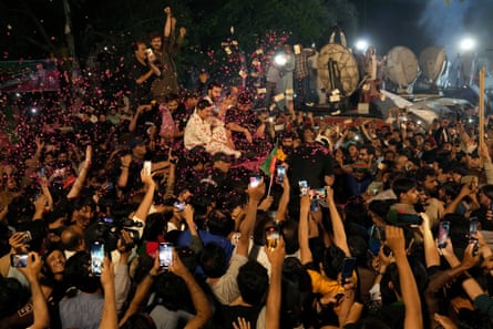 Supporters throw rose petals towards a vehicle carrying Khan on his arrival at his home in Lahore on Saturday.