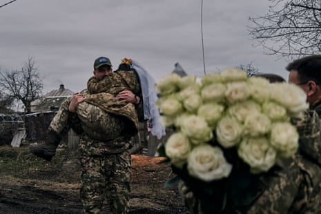 Ukrainian army medic Oleksander carries his bride and comrade Eugenia after their wedding ceremony in Lyman, Donetsk region, Ukraine.
